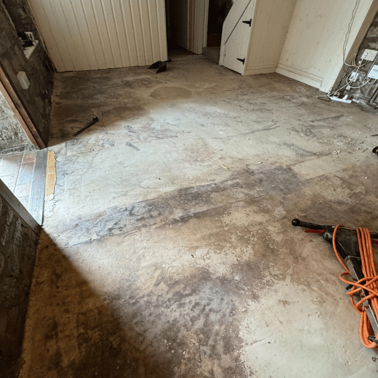 Damp Concrete Subfloor Covered with Old Adhesive and Paint Residue
